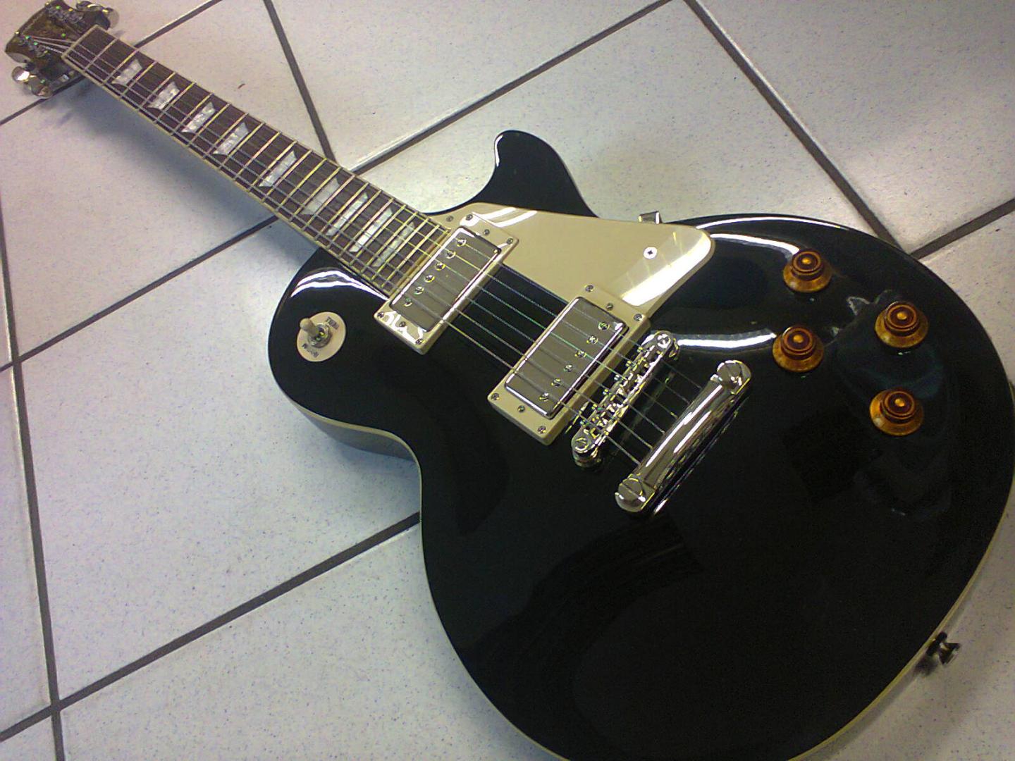 EPIPHONE LES PAUL STANDARD EB EPIPHONE LES PAUL STANDARD EB GUITARE ELECTRIQUE NOIR BRILLANT. CORPS MANCHE ACAJOU. TOUCHE PALISSANDRE. 2 MICROS HUMBUCKER. 2 VOL. 2 TON. SELECTEUR 3 POS. MECANIQUE GROVER BAIN D'HUILE. ACCASTILLAGE CHROME. PLAQUE CREME